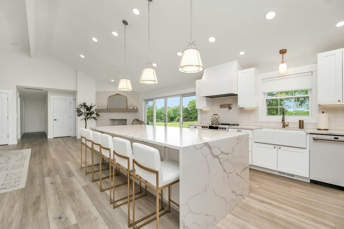 Remodeled kitchen with a marble island and white cabinets