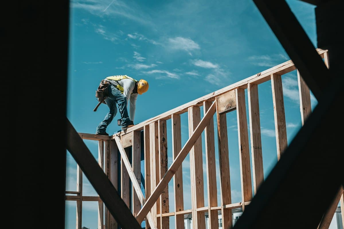 Worker on the wood frame of a new house under construction